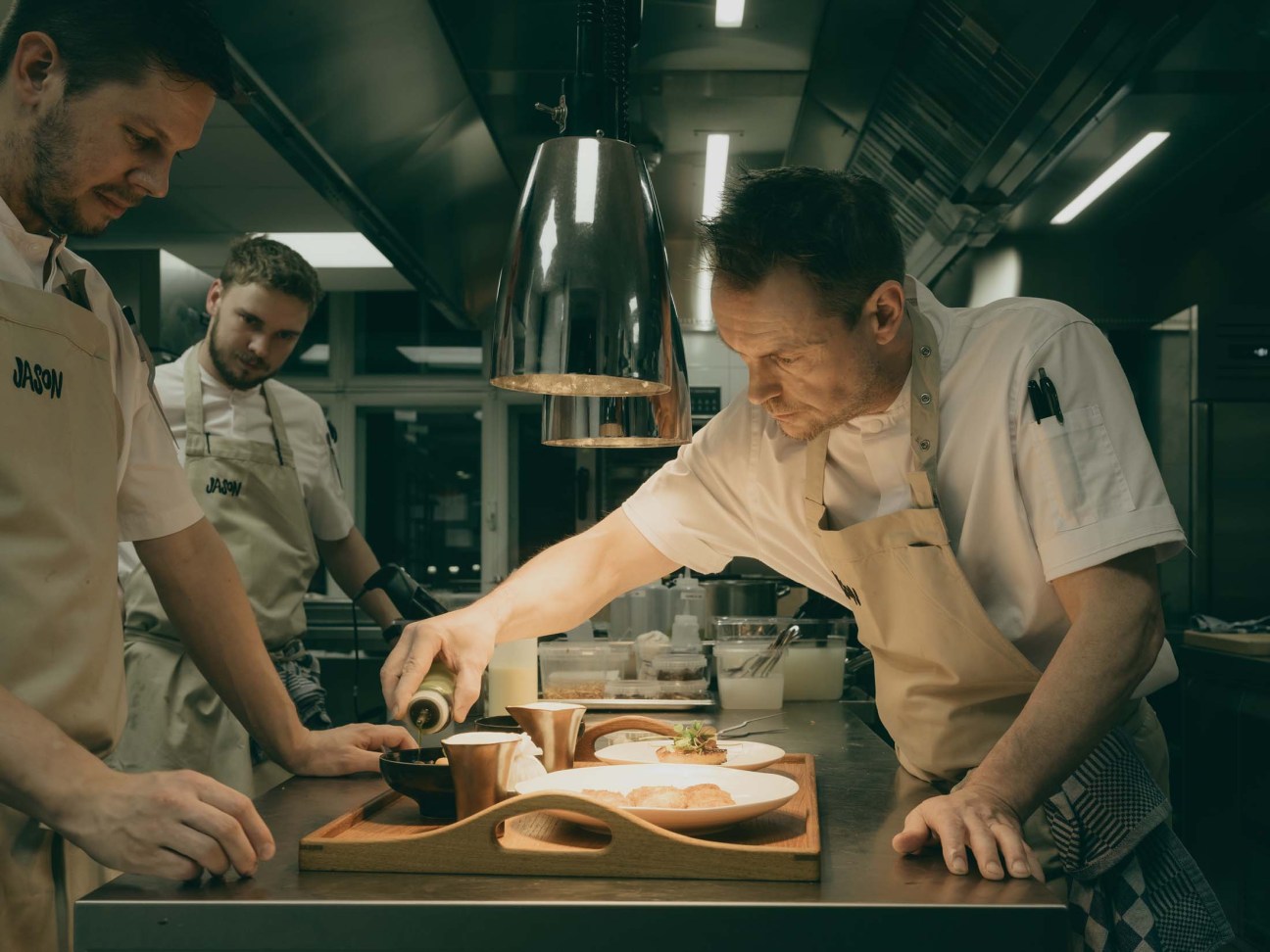 Chefs finishing up a dish in the kitchen