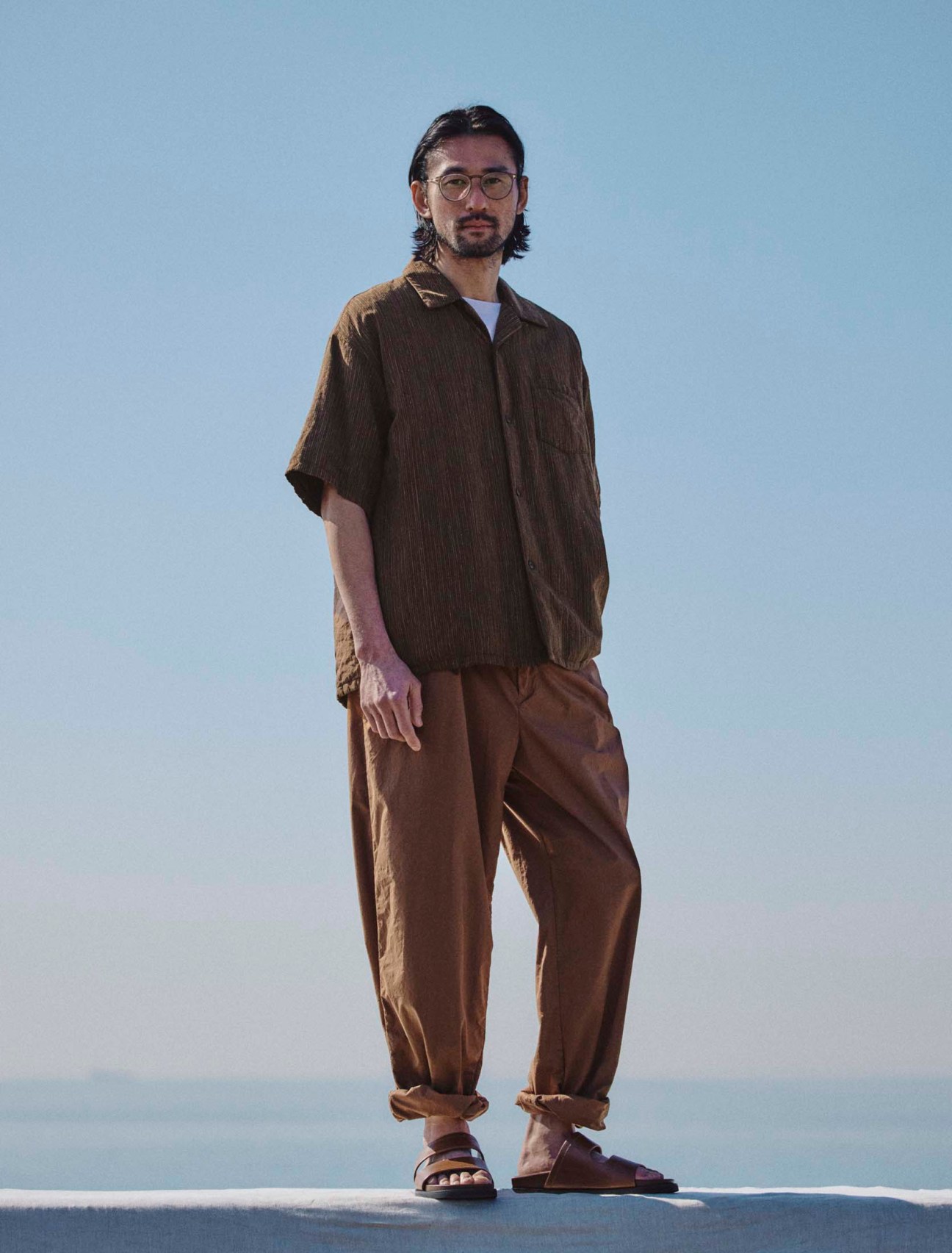 Shirt by Visvim, t-shirt by Eton, trousers by Graphpaper, sandals by JM Weston, glasses by Mykita