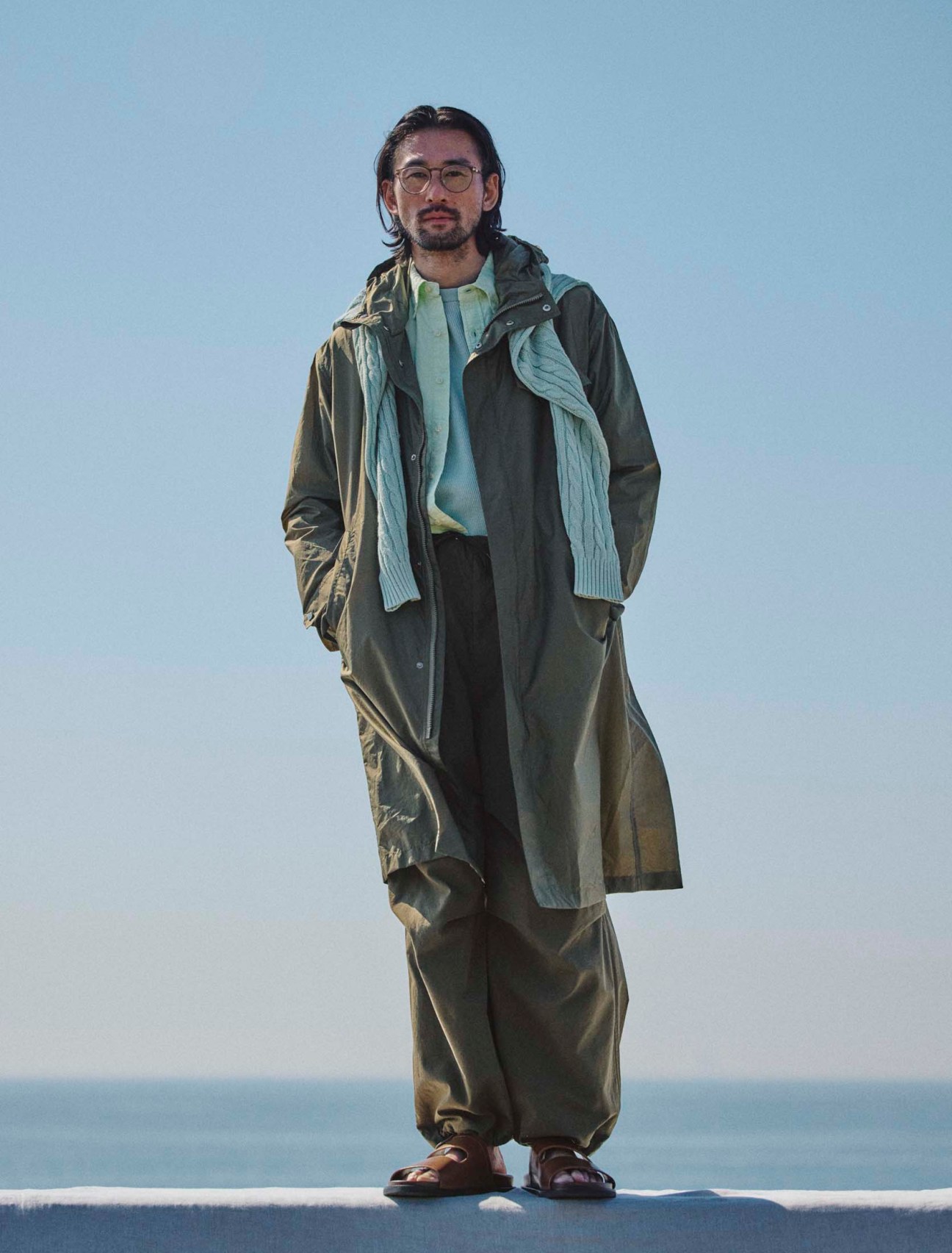 Coat by Herno, shirt by Polo Ralph Lauren, jumper by Beams Plus, thermalshirt by Polyploid, trousers by Blurhms, sandals by JM Weston, glasses by Mykita