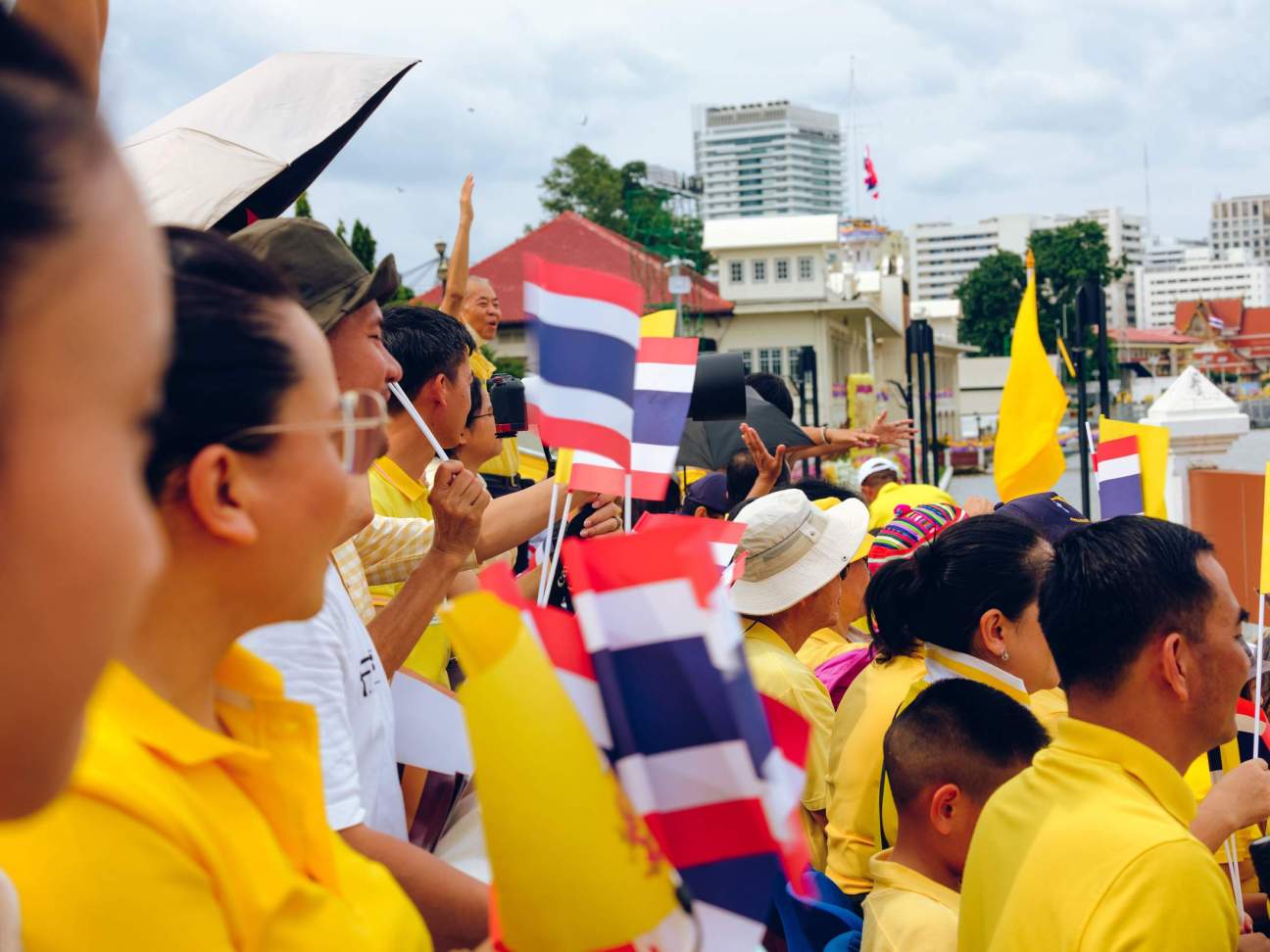 A crowd gather to watch the royal barge procession