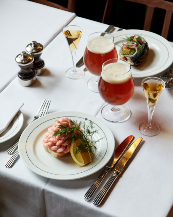 white tablecloth with a meal and glasses of beer and champagne