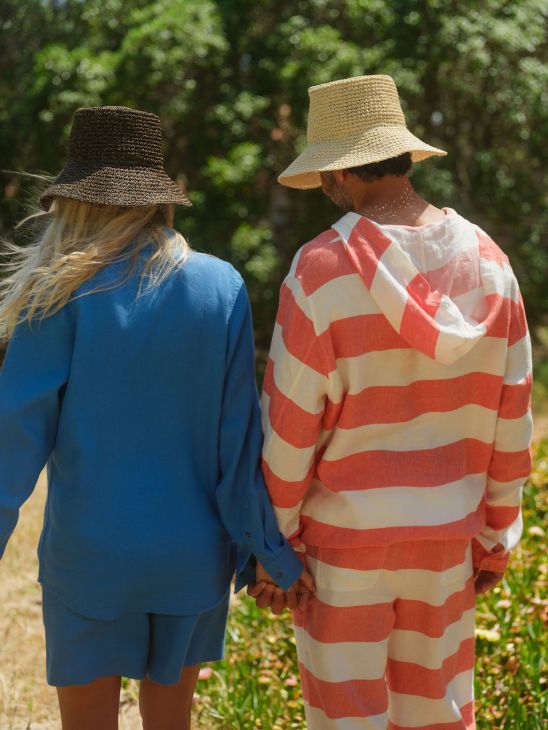 Two people holding hands with straw hats
