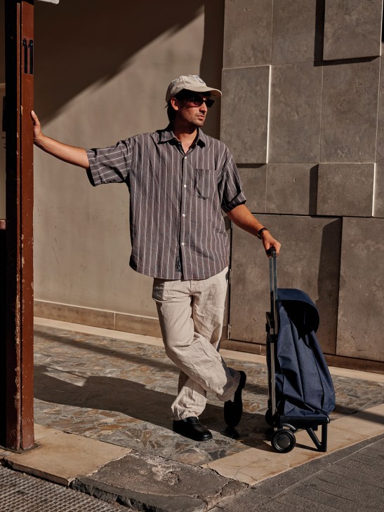 A man with a Rolser shopping trolley
