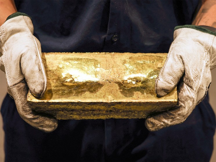 A refiner holds a gold brick after it was removed from a cast at the ABC Refinery smelter in Sydney