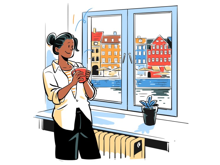 woman with hot tea looking out a window