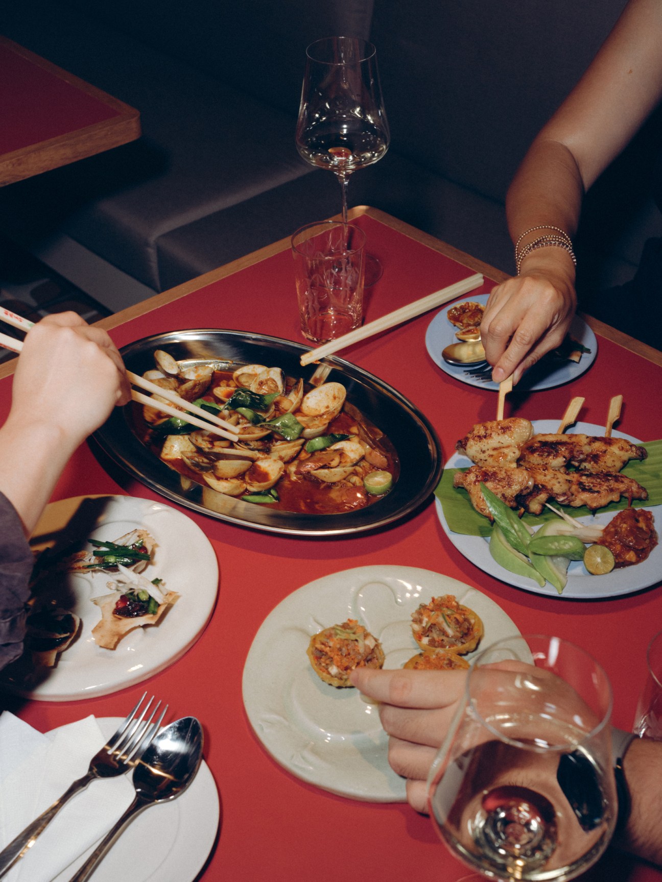 Thai food platters on a red table
