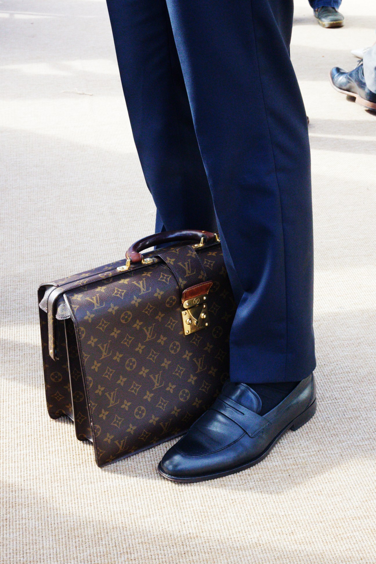 A well-dressed attendee in a suit walking outdoors