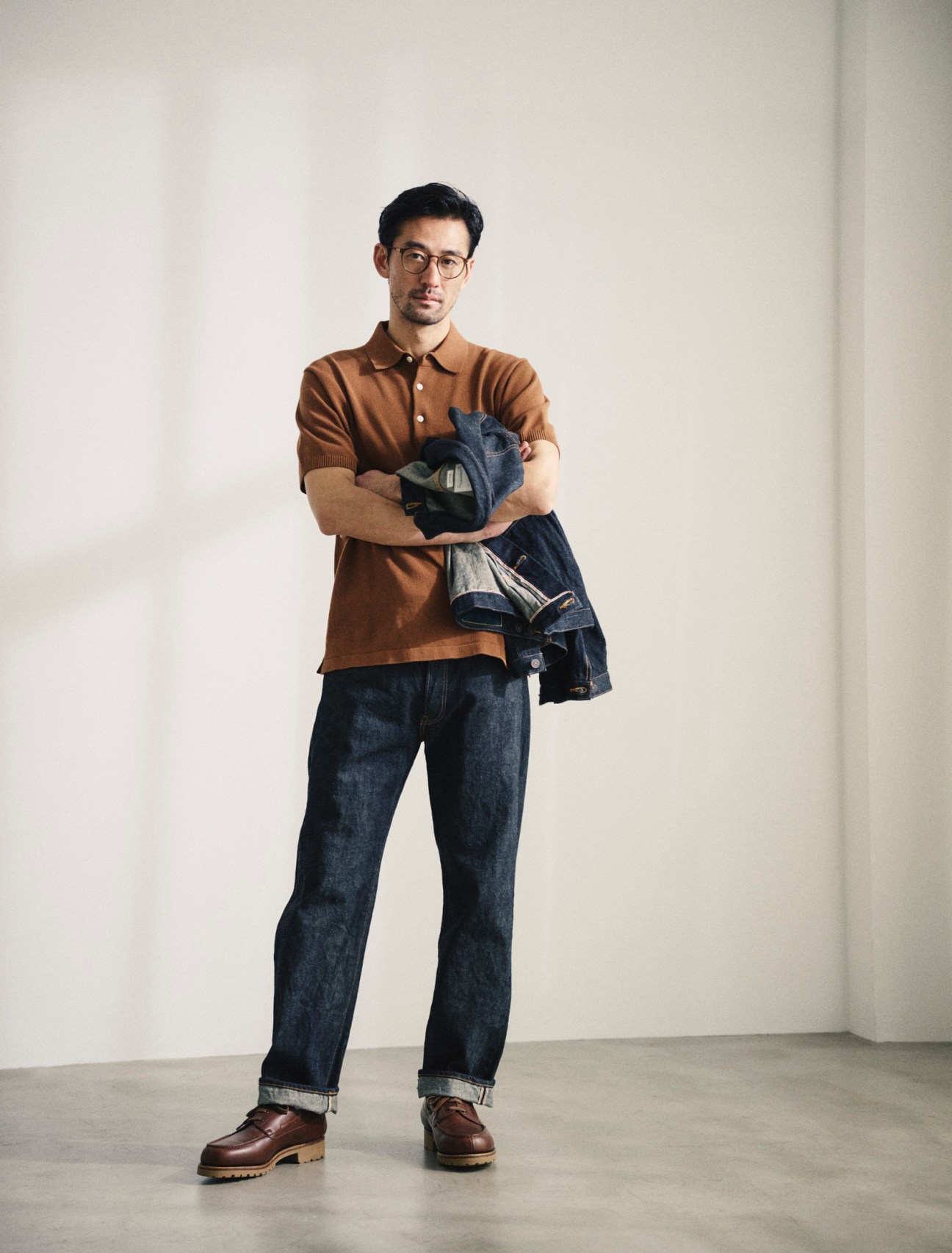 Jacket and jeans by Visvim, polo shirt by Beams Plus, shoes by JM Weston, glasses by Mykita