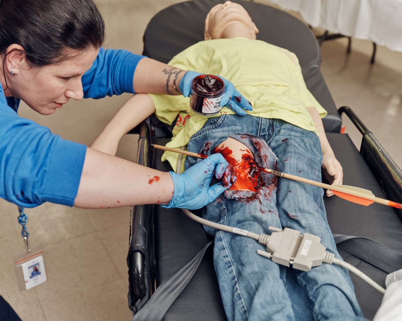 Training staff preparing a simulated arrow wound for a mannequin