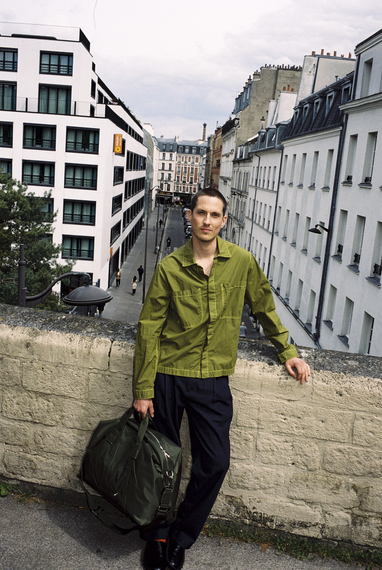 Miles le Gras wears shirt by Sunnei, trousers by The Frankie Shop, bag by Rimowa
