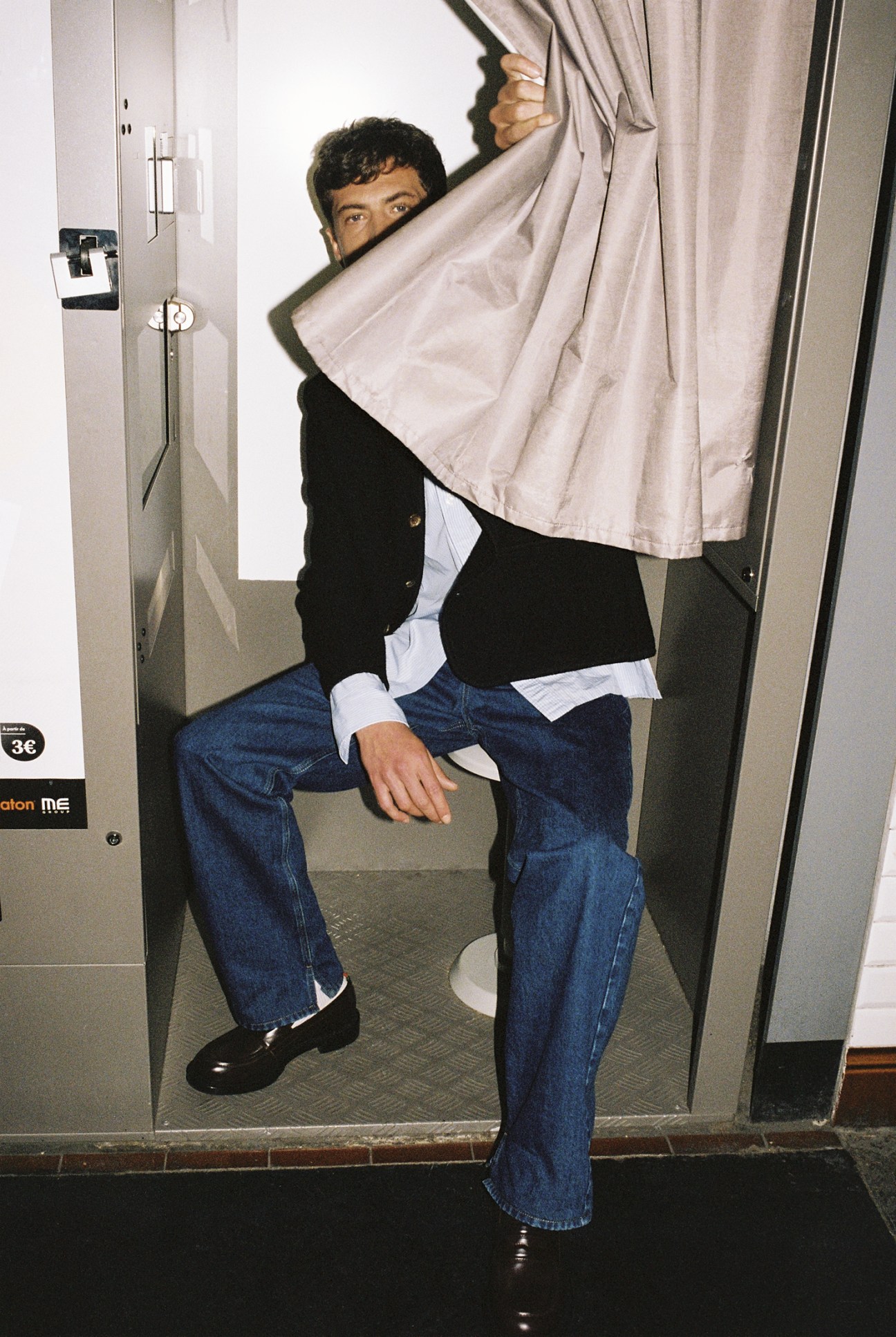Timothé Echelard wears jacket by Rier, shirt by Charvet, jeans, socks and shoes by Gucci