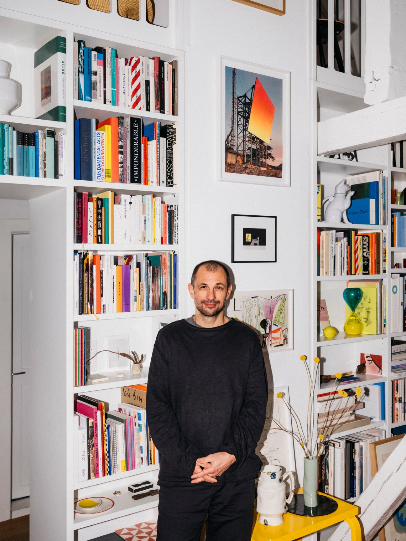 a young man in front of a book shelf