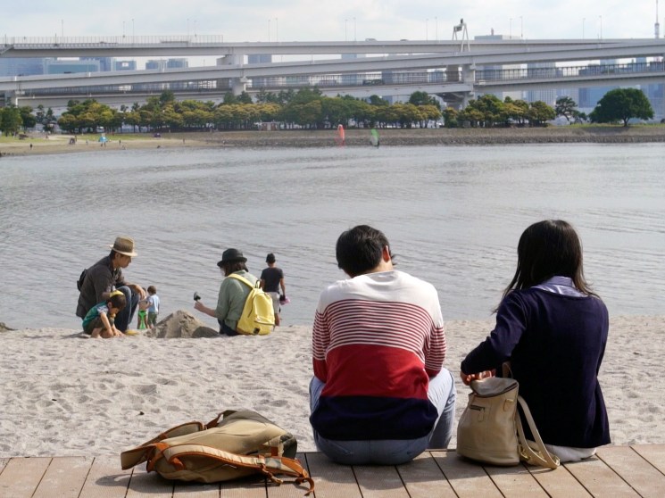 People relaxing on a beach in Tokyo.